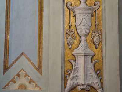 Mentre le pareti conservano una decorazione con foglie e piante rampicanti dorate che cingono vasi bianchi...